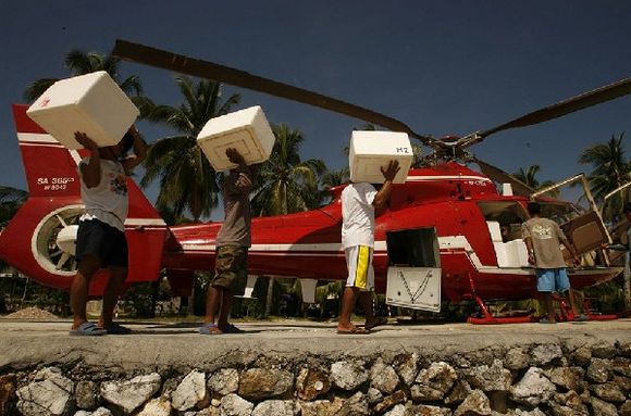 people taking oyster carton boxes to red helicopter 