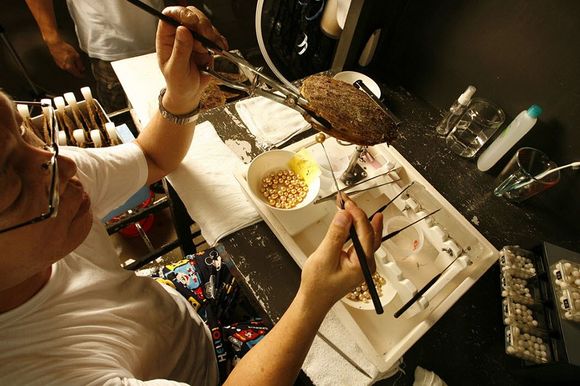 checking oyster for golden pearls near a bowl full with pearls