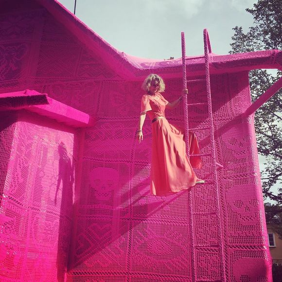 artist covers a house in pink crochet 